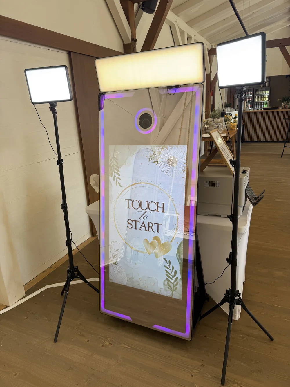 Trenz Events Fotospiegel mit floralem Startbildschirm und seitlicher Beleuchtung bei einer Hochzeit