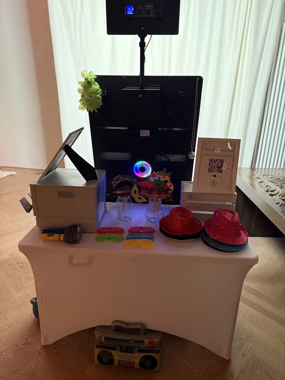 Requisitentisch mit Hüten, Brillen und Fotodrucker hinter dem Fotospiegel